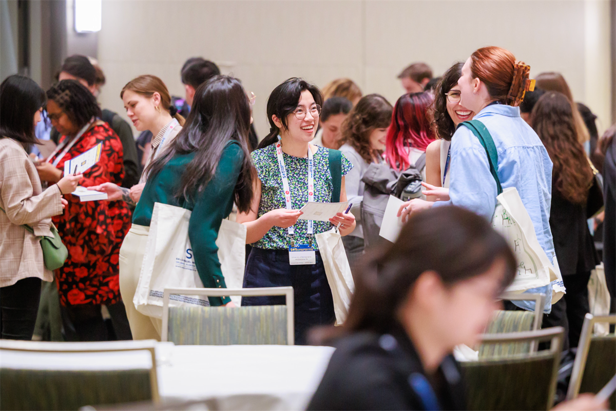 People standing in a circle, smiling and talking to each other.